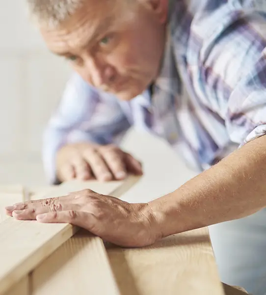 Carpintero revisando el acabado de una tabla de madera